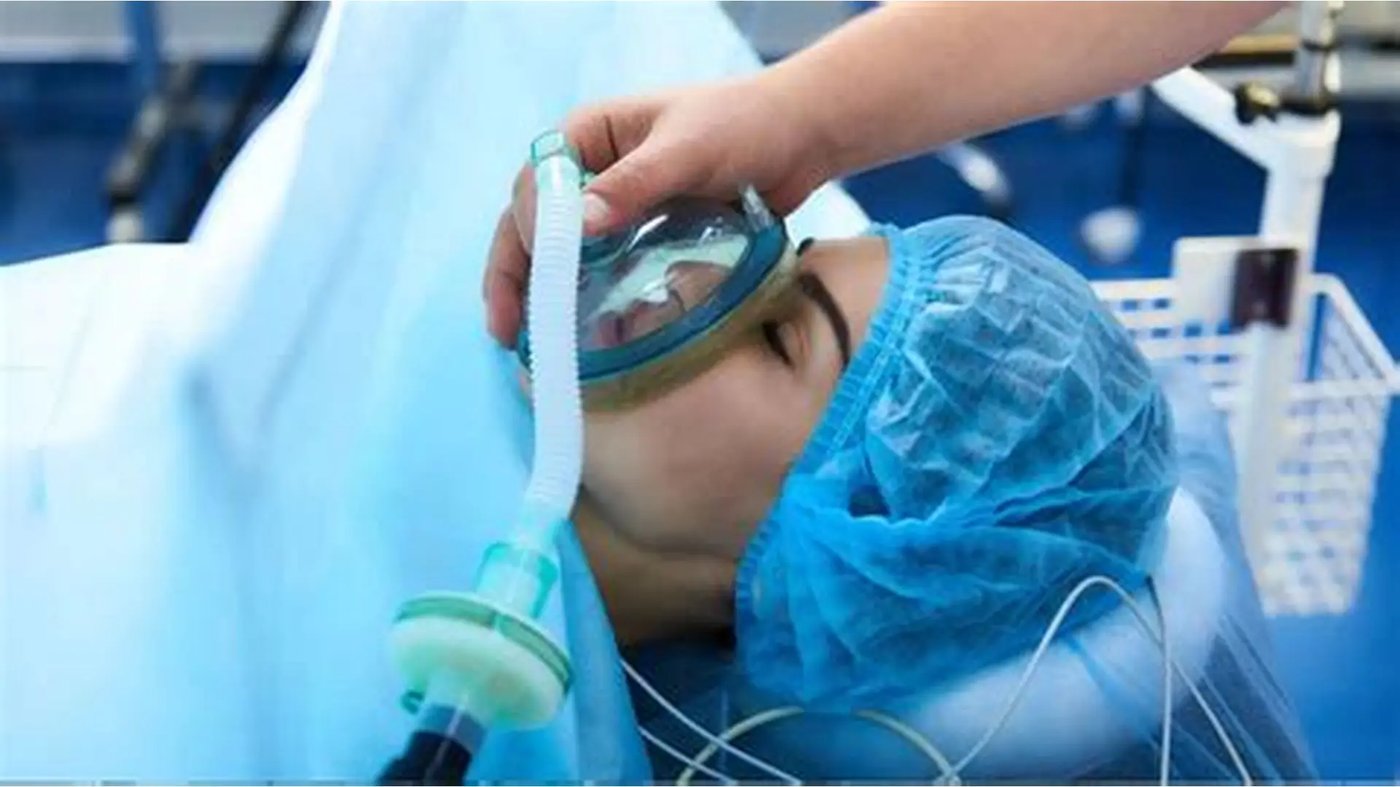 Patient receiving inhalational sedation via face mask with monitoring